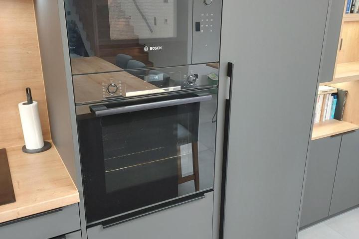 Moderná kuchyňa v tvare L s ostrovčekom prepojená s dizajnovou knižnicou v jednotnom štýle